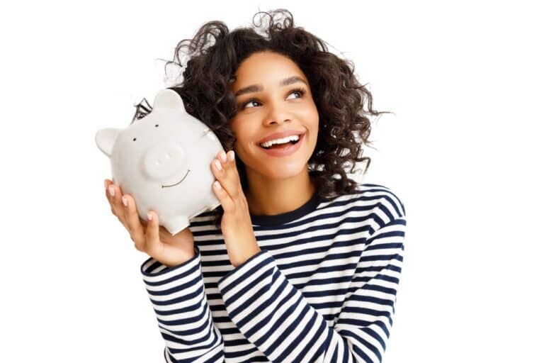 donna sorridente tiene in mano un salvadanaio pensando ai risparmi derivanti dai bonus