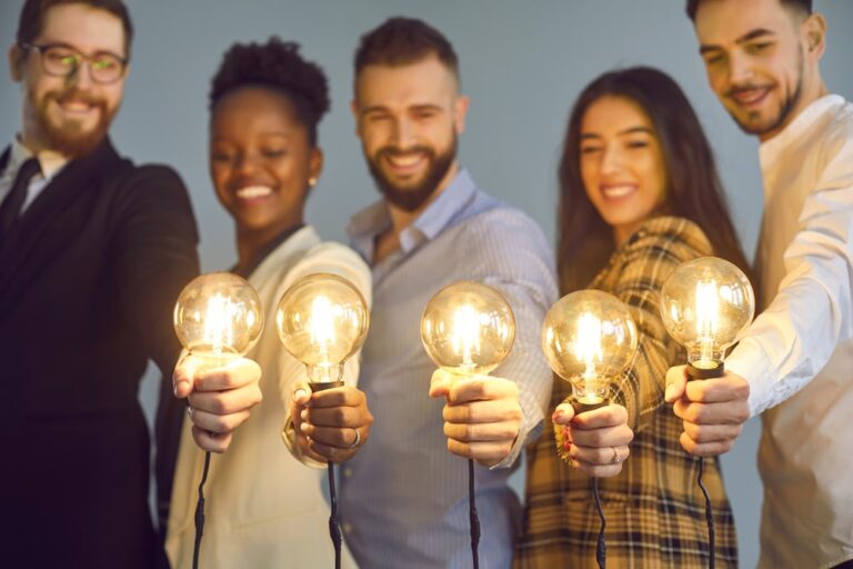 5 persone diverse tengono in mano ciascuno una lampadina accesa grazie al fatto che sono in una comunità energetica rinnovabile