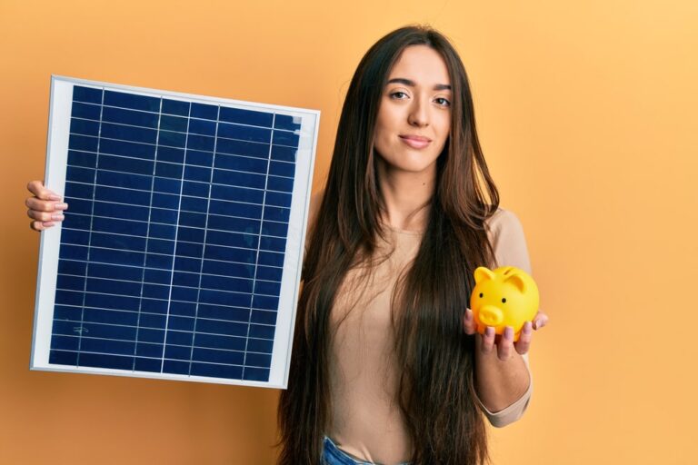 ragazza che tiene in una mano un pannello fotovoltaico e nell'altra un salvadanaio dimostra i benefici del fotovoltaico attraverso le agevolazioni fiscali