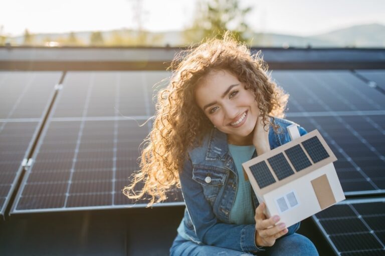 una ragazza davanti al suo impianto fotovoltaico sorride per il costo degli impianti fotovoltaici nel 2025