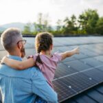 Un padre tiene la sua bambina in braccio e con lo sguardo osservano in lontananza, scrutando quali saranno i prezzi degli impianti fotovoltaici nel 2025