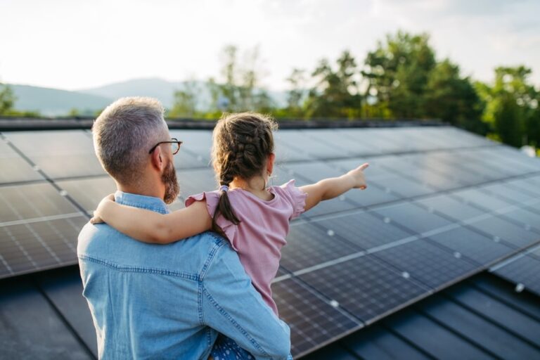 Un padre tiene la sua bambina in braccio e con lo sguardo osservano in lontananza, scrutando quali saranno i prezzi degli impianti fotovoltaici nel 2025