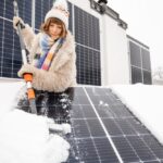 donna rimuove la neve dal pannello fotovoltaico il cui costo varia in base al luogo e alle dimensioni