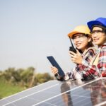 due tecnici asiatici sorridono perché il prezzo dei loro moduli fotovoltaici