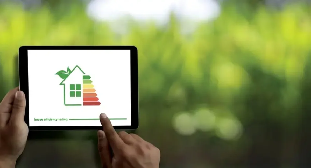 tDue mani tengono un tablet che mostra l'icona di una casa green