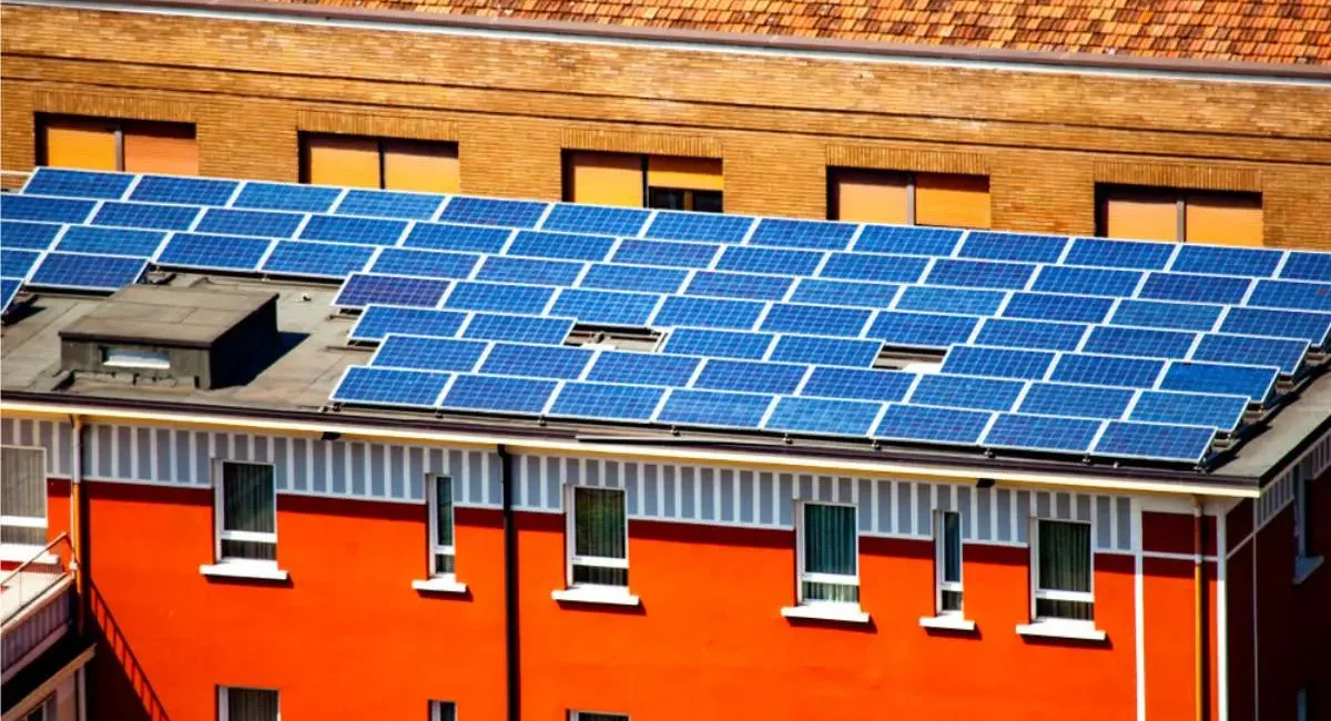 Energia verde. Pannelli solari sul tetto di un edificio rosso nel centro storico di Brescia, Lombardia,