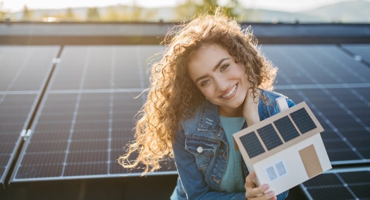 una ragazza davanti al suo impianto fotovoltaico sorride per il costo degli impianti fotovoltaici nel 2025